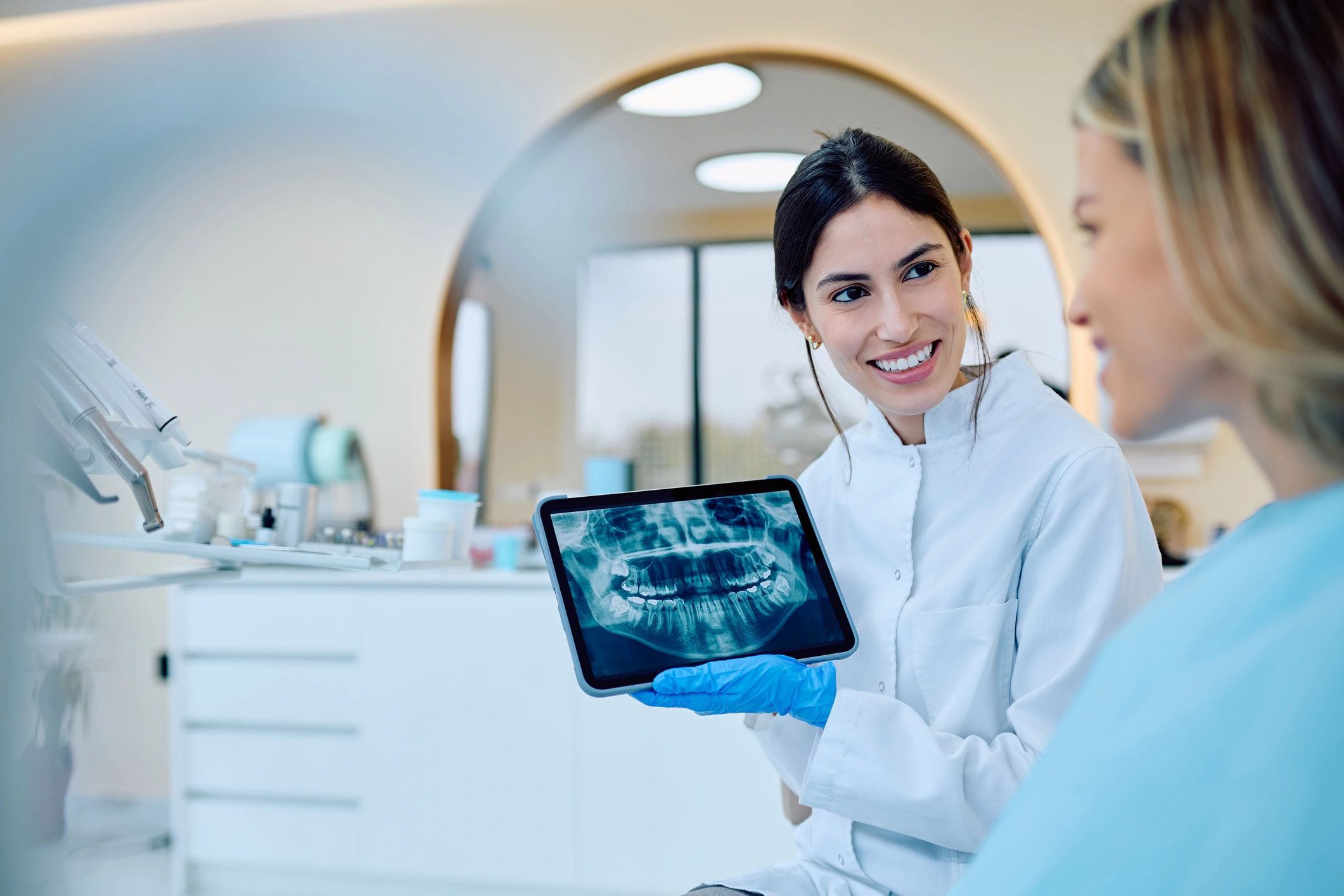 Dentist explaining implant treatment options to a patient using digital imaging