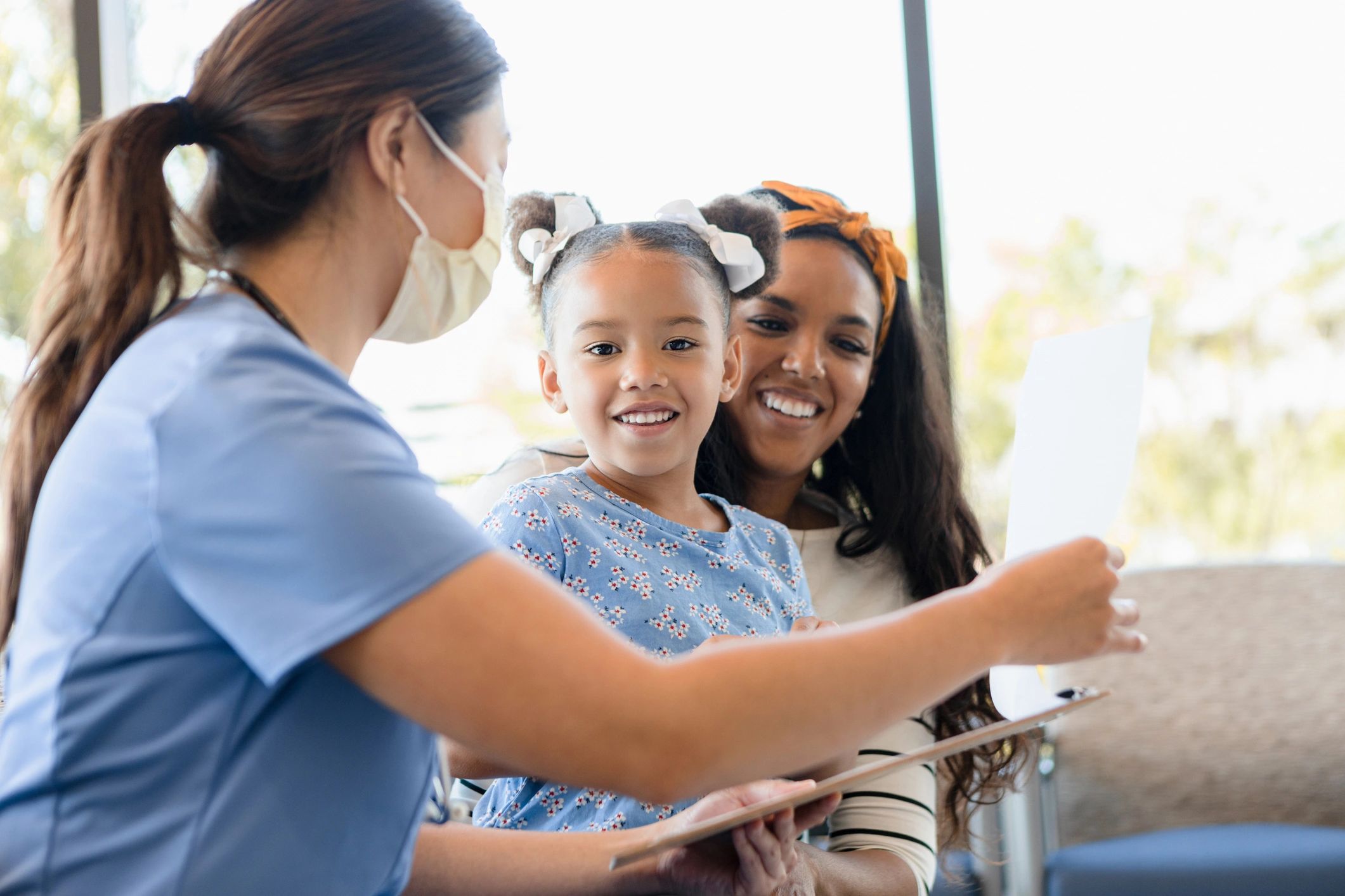 Mother and daughter smiling in a bright family dental setting