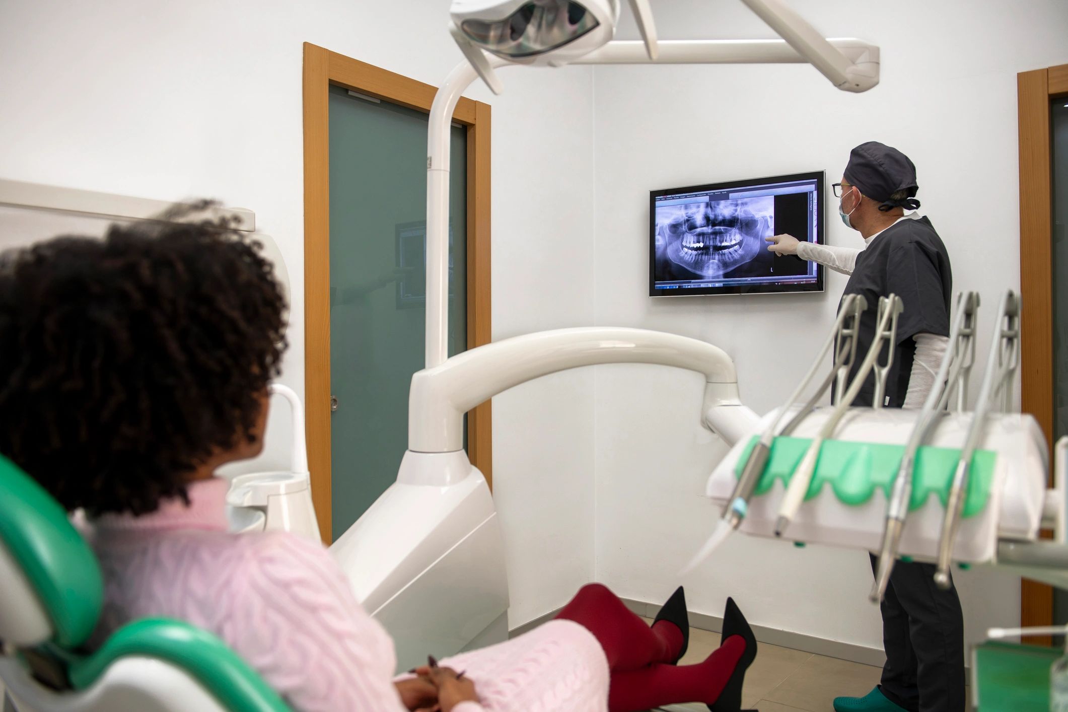 Dentist showing dental x-ray to patient during implant planning